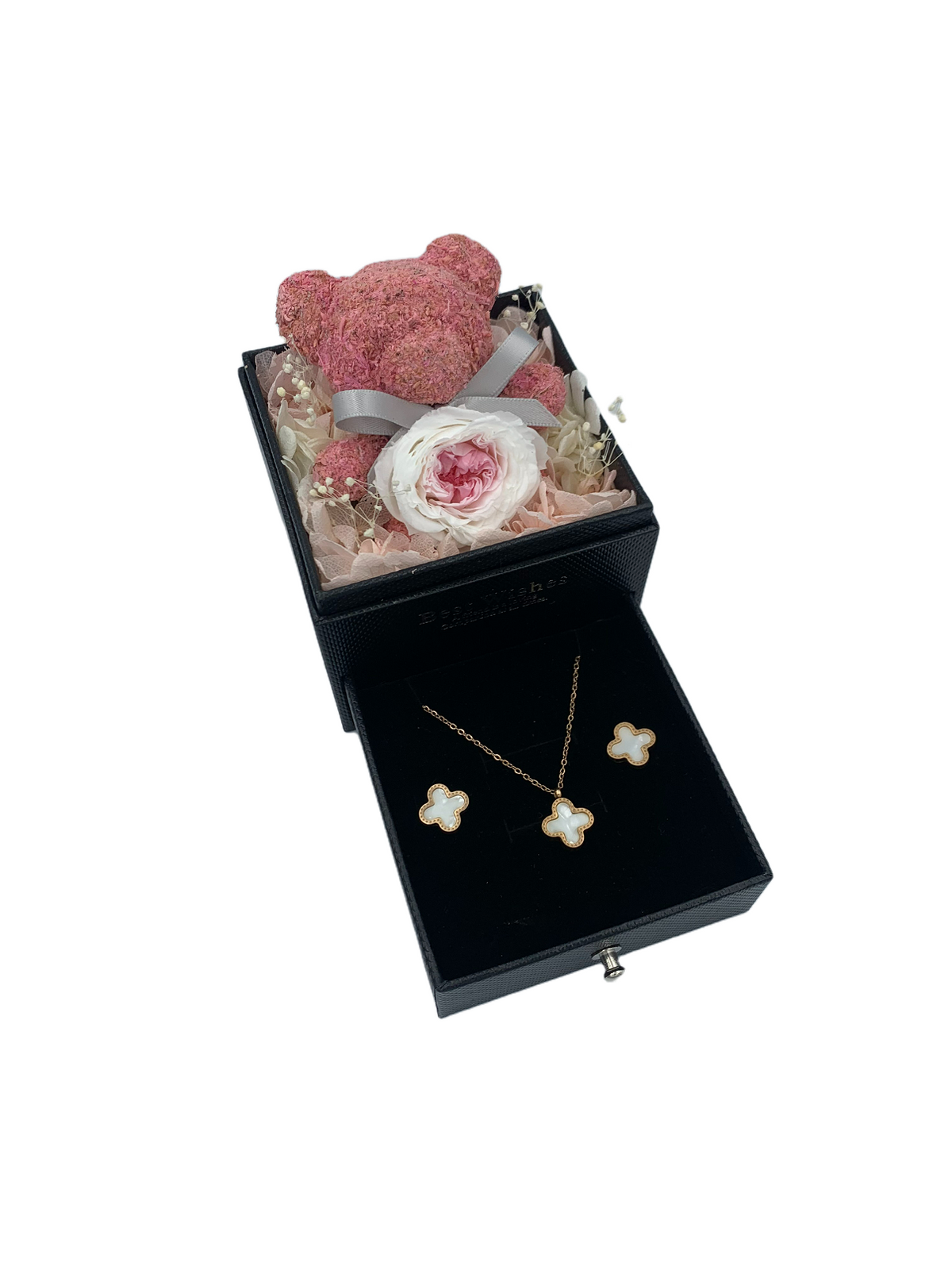 Plush teddy cradling a pink preserved rose that lasts 3+ years