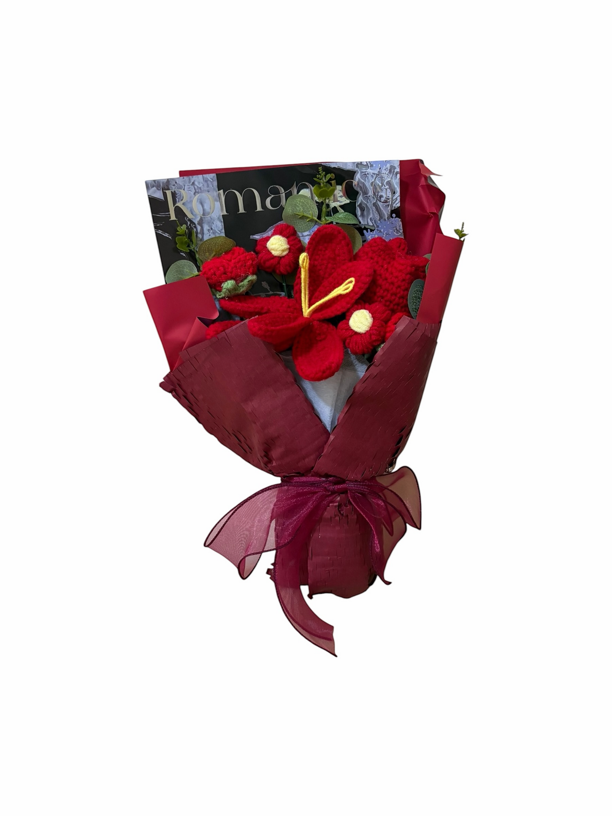 Red knitted flower bouquet, hand-crocheted lily with yellow centre wrapped in red paper and tied with a burgundy ribbon